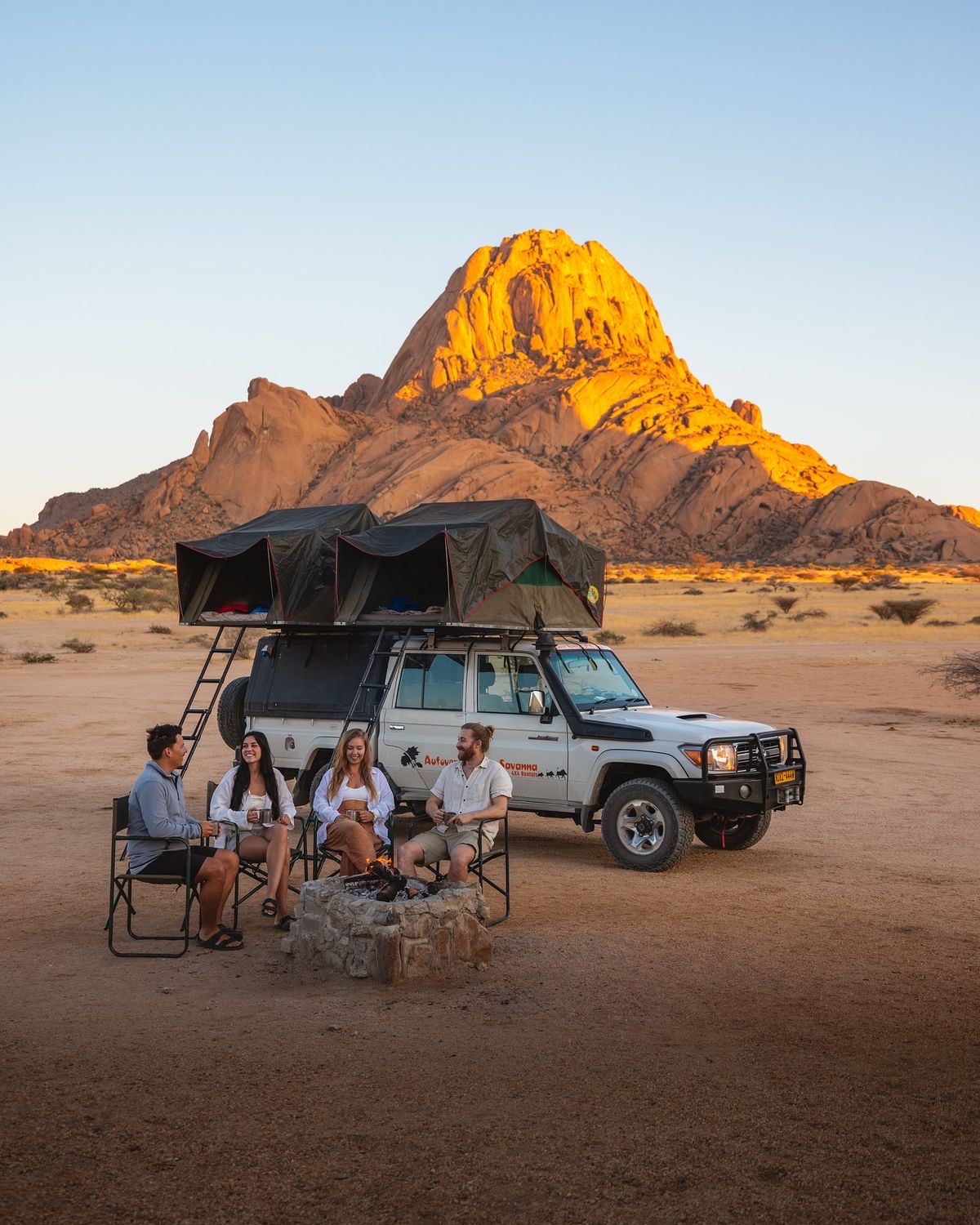 Rooftop tent 4x4 camp under Spitzkoppe granite peaks at sunset