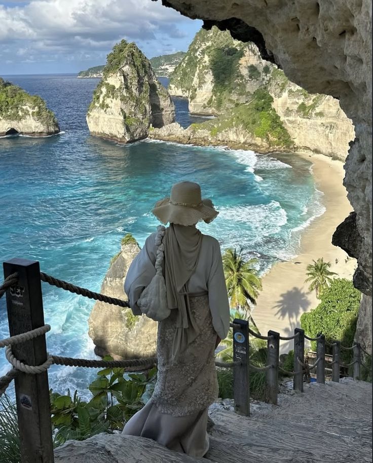 Traveller in modest beachwear admiring a turquoise hidden cove framed by limestone cliffs and palm trees.