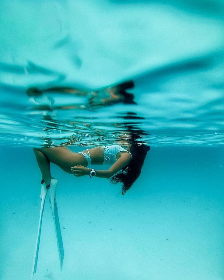 Freediver in fins gliding through crystal-clear turquoise water on a Zanzibar snorkelling and freediving tour.
