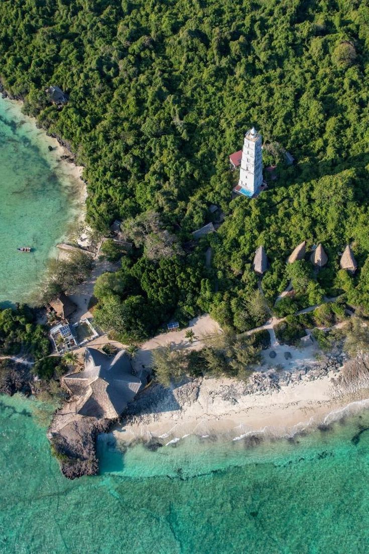 Aerial view of the historic Chumbe Island lighthouse and eco-bandas surrounded by forest and coral reef.