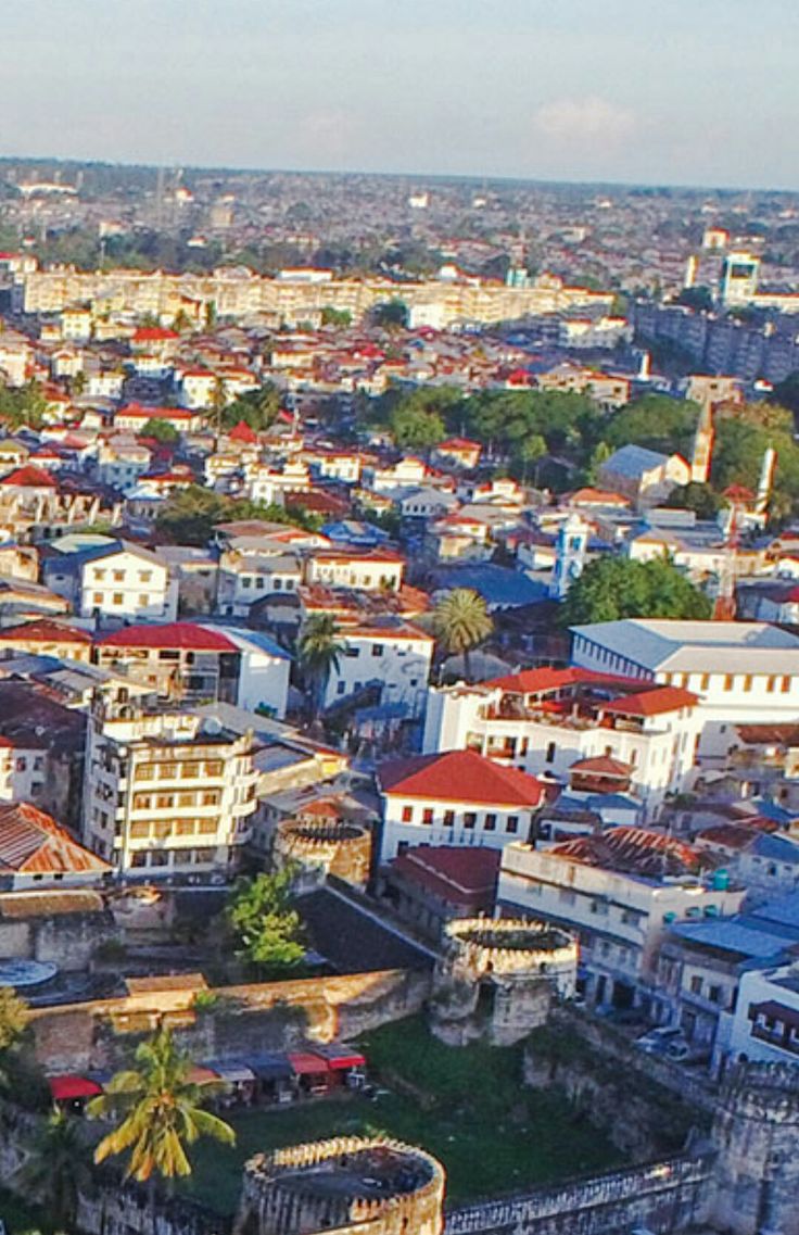 Aerial view of the red-tiled rooftops and Old Fort ramparts of historic Stone Town, a UNESCO World Heritage site.